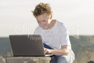 Schoolboy play the game on laptop