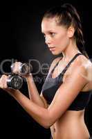 Pretty young woman lifting dumbbells in sportswear