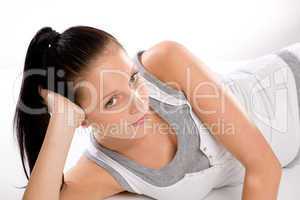 Woman lying in sportswear on white background