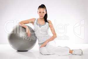 Young Caucasian woman leaning on fitness ball