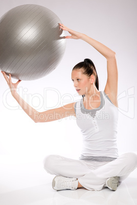 Slim young woman exercising from sitting position