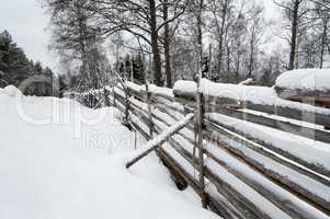 Rustic wooden fence covered in snow