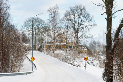 Red painted Swedish wooden house in a wintry landscape