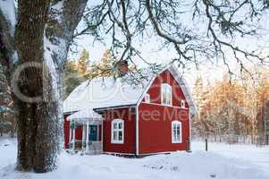 Rot gestrichenes Schwedenhaus in Winterlandschaft in Småland, Schweden