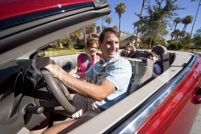 Family Driving Red Convertible Car