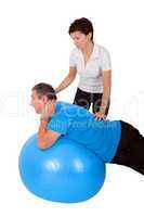 Woman helps man when practicing with the exercise ball