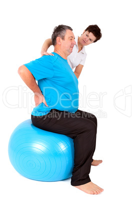 Woman helps man when practicing with the exercise ball