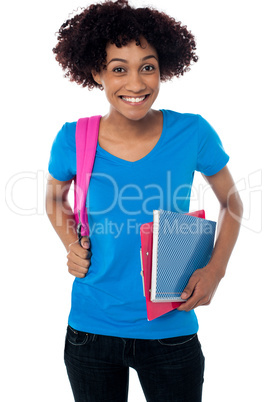 College student carrying back pack, book and clipboard