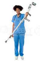 Lady doctor handing over crutches to the patient