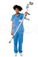 Orthopedic lady doctor with crutches in hand