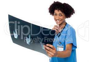 Attractive young medical professional holding x-ray sheet