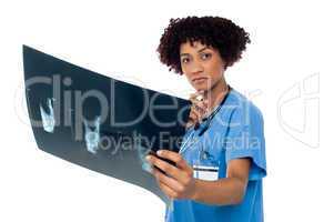 Young serious lady surgeon holding x-ray sheet
