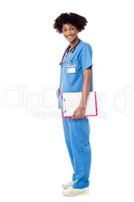 Medical expert posing sideways, holding clipboard
