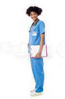 Medical expert posing sideways, holding clipboard