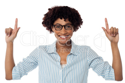 Excited woman pointing upwards