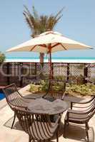 Chairs and umbrella near swimming pool by a beach of the luxury