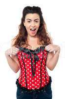 Excited woman adjusting her polka dotted corset top