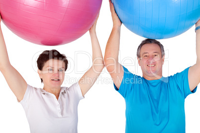 Man and woman holding up exercise ball