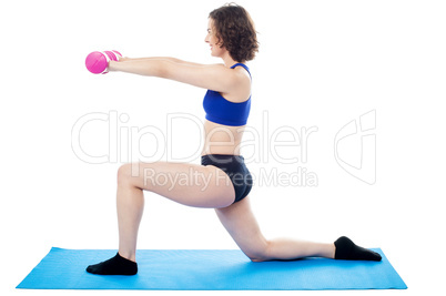 Woman exercising with dumbbells, arms outstretched