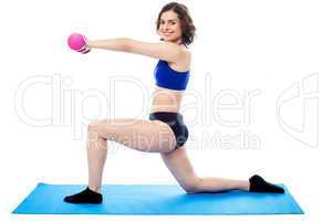 Fit lady with dumbbells kneeling on one leg