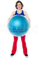 Female instructor displaying pilates ball used in gym
