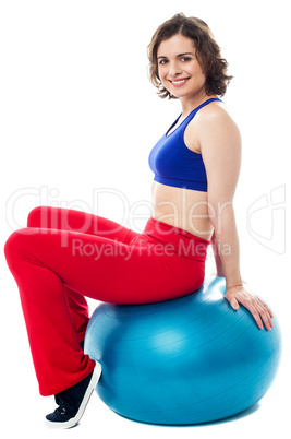 Woman relaxing on big exercise ball after workout