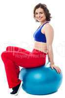 Woman relaxing on big exercise ball after workout