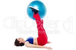 Fit woman holding exercise ball between legs