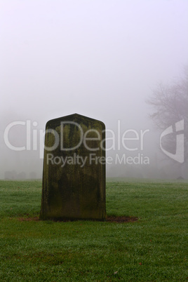 Single gravestone in a spooky graveyard on a foggy day