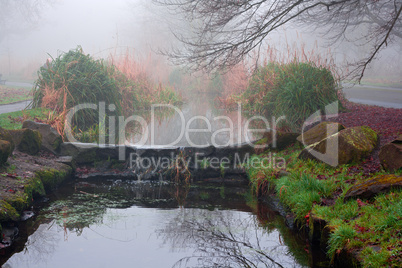 Small stream waterfall on a foggy winters day