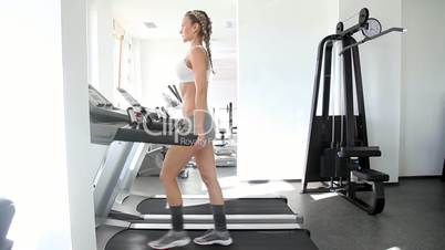 Athletic woman running on the track in gym