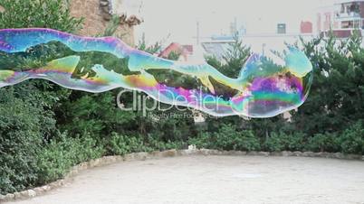 Large soap bubble waving in the air and bursted out