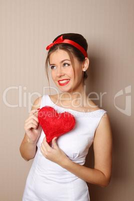 Beautiful young woman holding a red heart