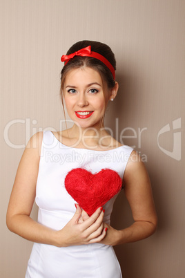 Beautiful young woman holding a red heart