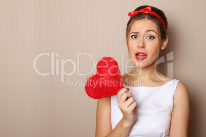 Beautiful young woman holding a red heart