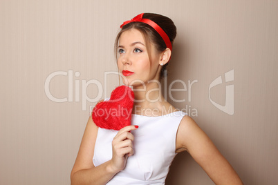 Beautiful young woman holding a red heart