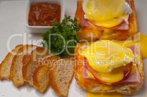 eggs benedict on bread with tomato and ham