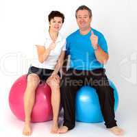 Woman and man with exercise ball show approval