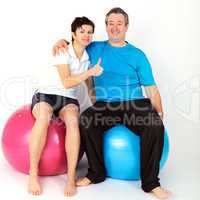 Woman and man with exercise ball show approval