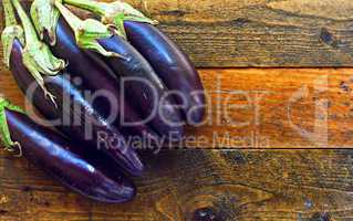 Fresh organic aubergines on rustic wooden table