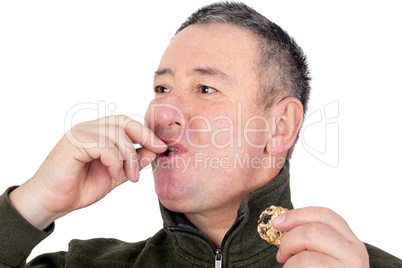 Man eating cookies and licks his fingers