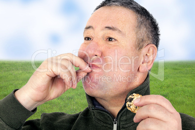 Man eating cookies and licks his fingers