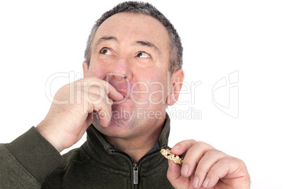 Man eating cookies and licks his fingers