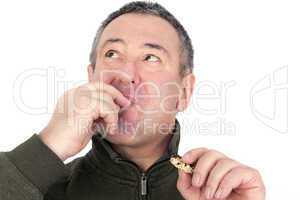 Man eating cookies and licks his fingers