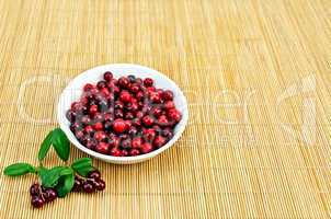 Lingonberry in a white cup on a bamboo mat