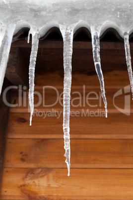 Icicles against wooden wall