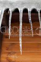 Icicles against wooden wall