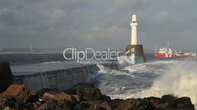 Oil support vessel entering Aberdeen harbour, Scotland, in heavy seas