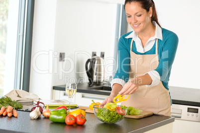 Happy woman making salad kitchen vegetables cooking