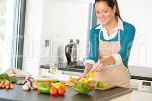 Happy woman making salad kitchen vegetables cooking